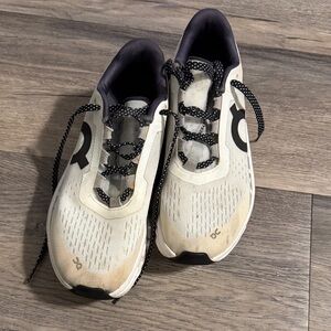 On Running Cream and Black Athletic Shoes